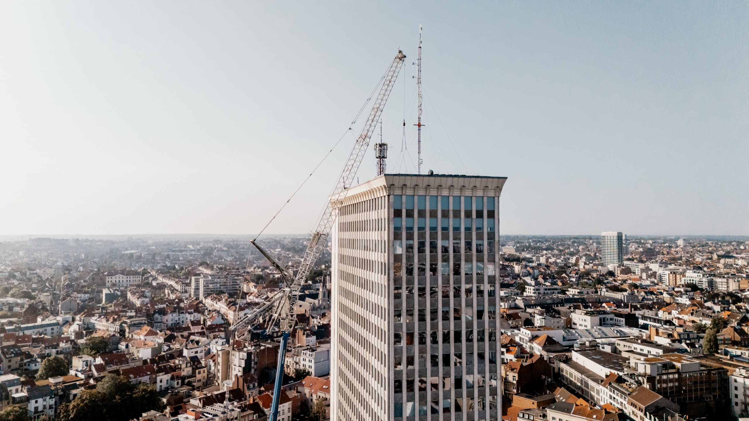La tour et la flèche de la grue qui la dépasse, sur l’horizon de la ville.