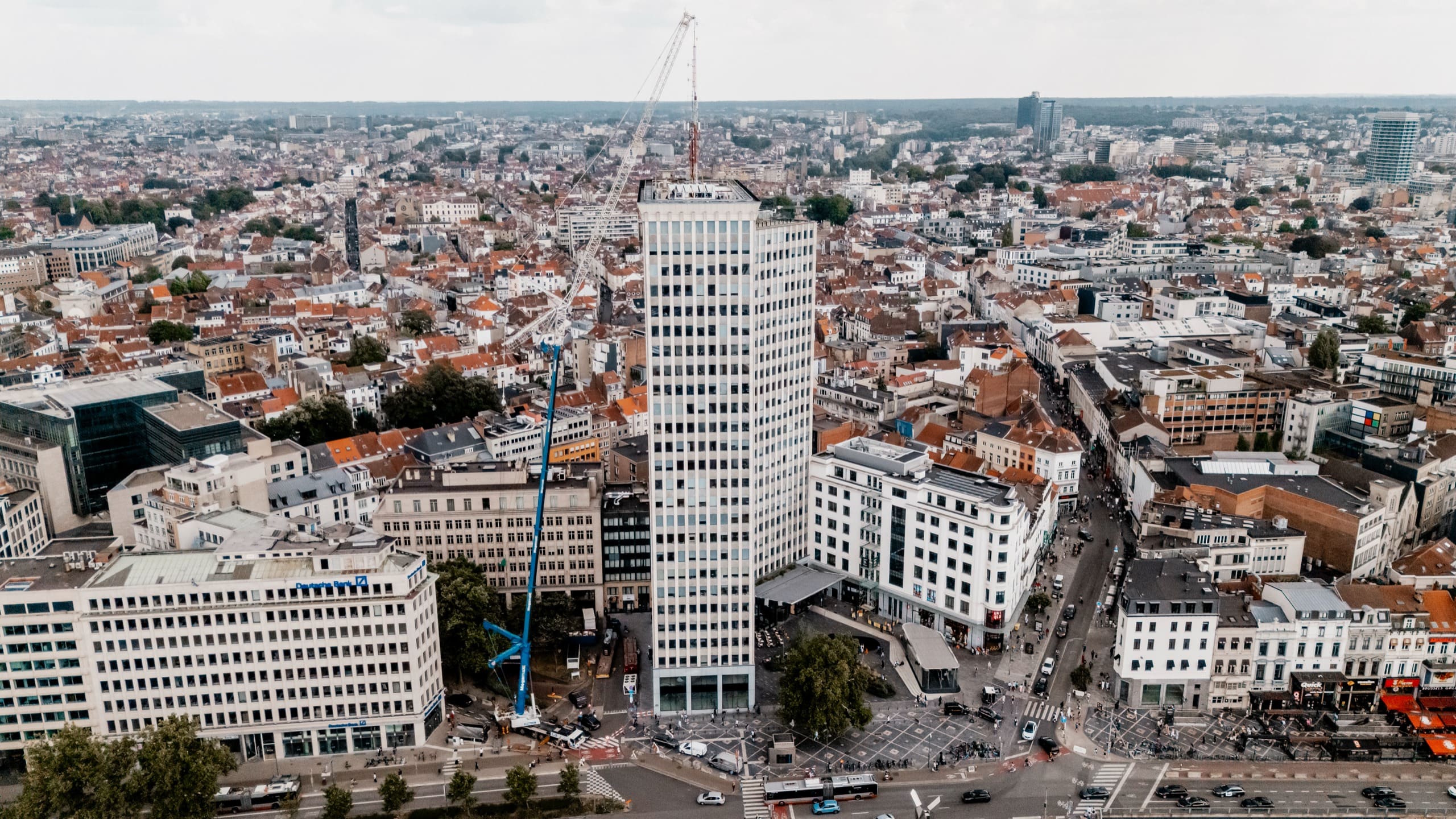 Vue aérienne de la tour au milieu de son quartier, la grue mobile sur le boulevard.
