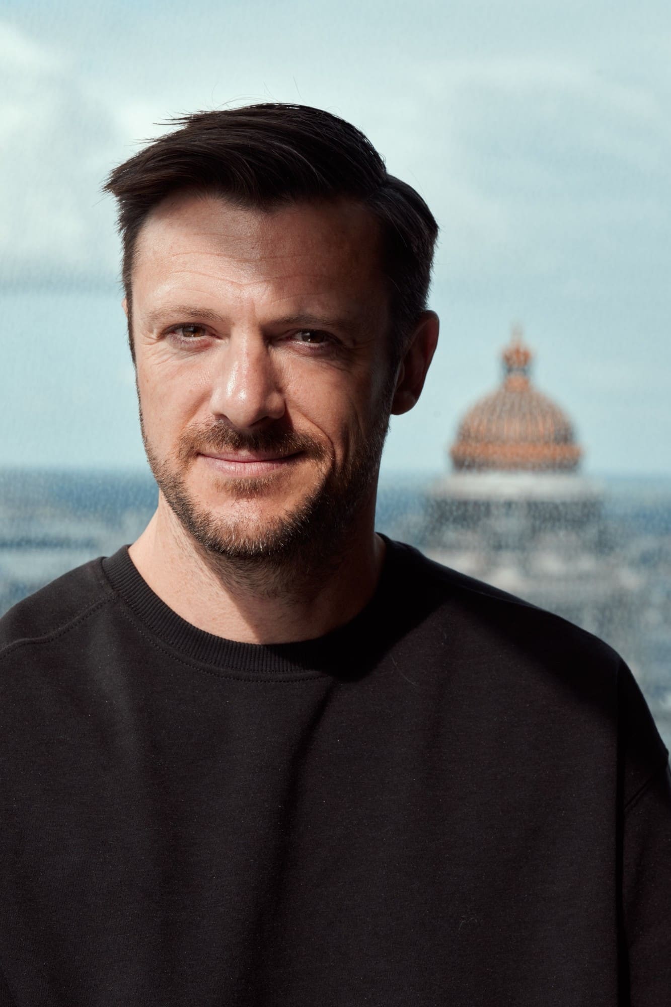 Portrait de Thomas Blairon, photographe et vidéaste, devant une vue de Bruxelles.